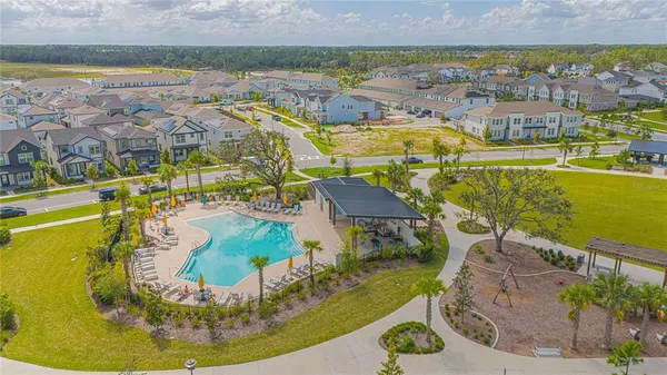 an aerial view of a swimming pool with outdoor seating