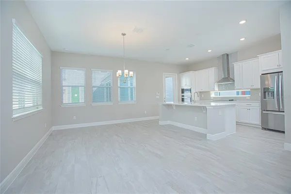a view of kitchen with wooden floor and electronic appliances