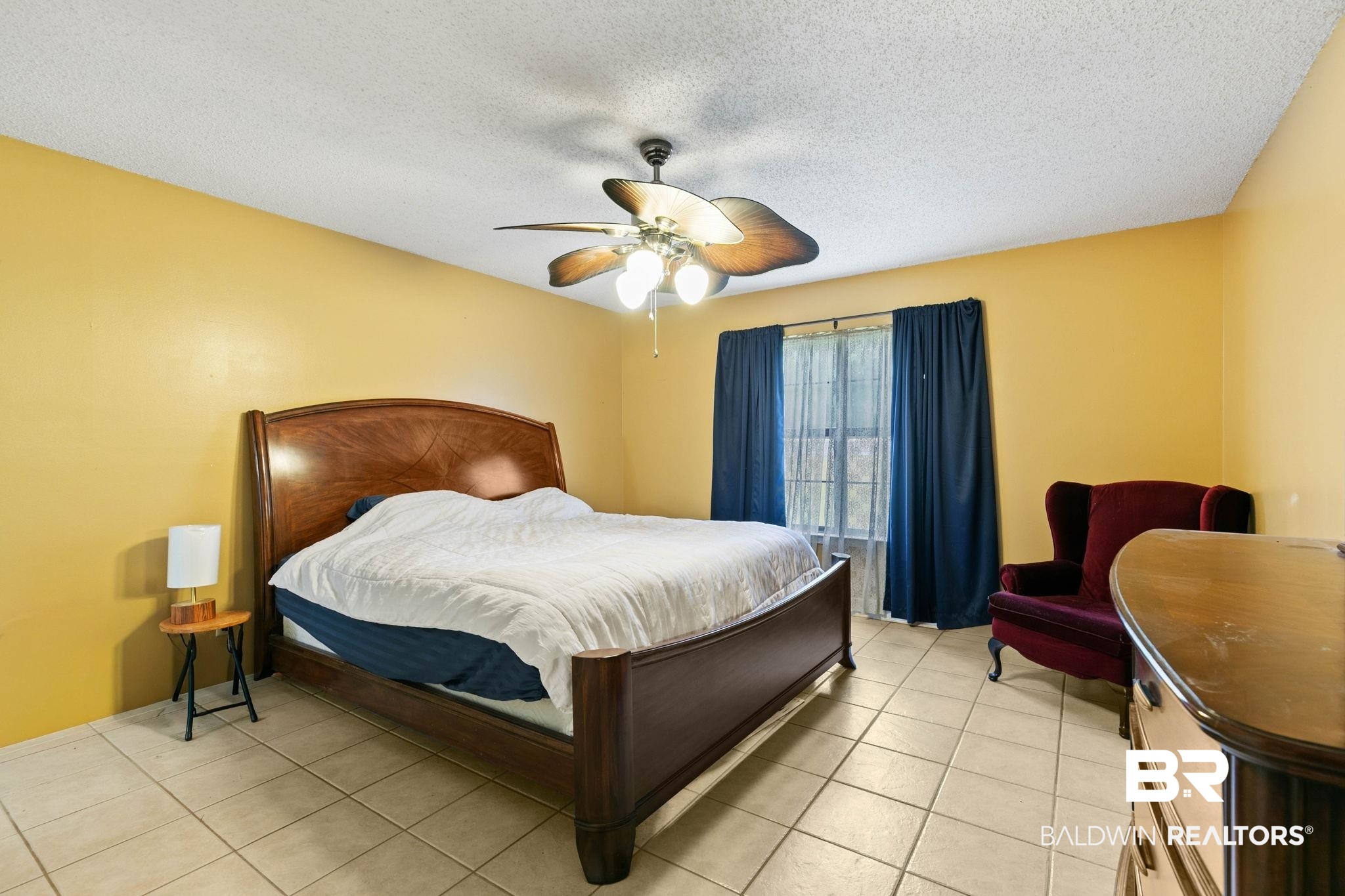 13653 Roberts Road Loxley, AL 36551 - Photo 23 of 33 Room featuring light-colored tile flooring, a window with curtains, and a ceiling fan with integrated lighting