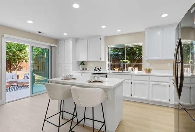 a kitchen with stainless steel appliances granite countertop a sink and a refrigerator
