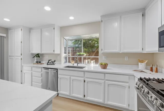 a kitchen with white cabinets and a stove