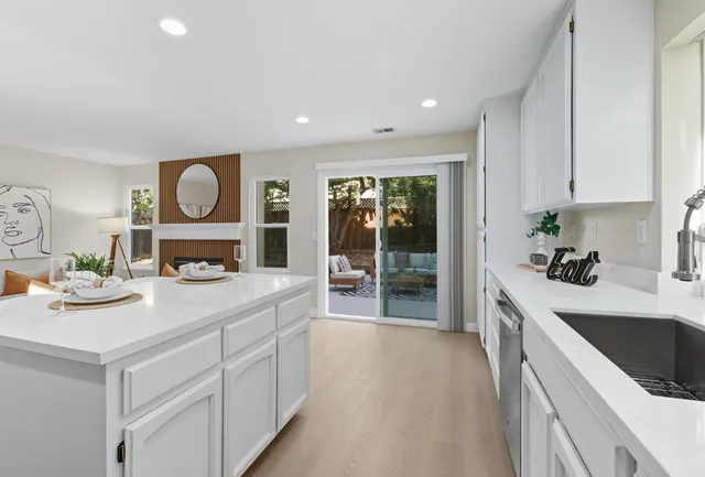 a kitchen with kitchen island a stove a sink and a cabinets with wooden floor