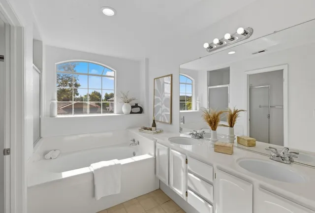 a bathroom with a tub a sink and mirror