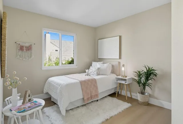 a bedroom with a bed and a potted plant