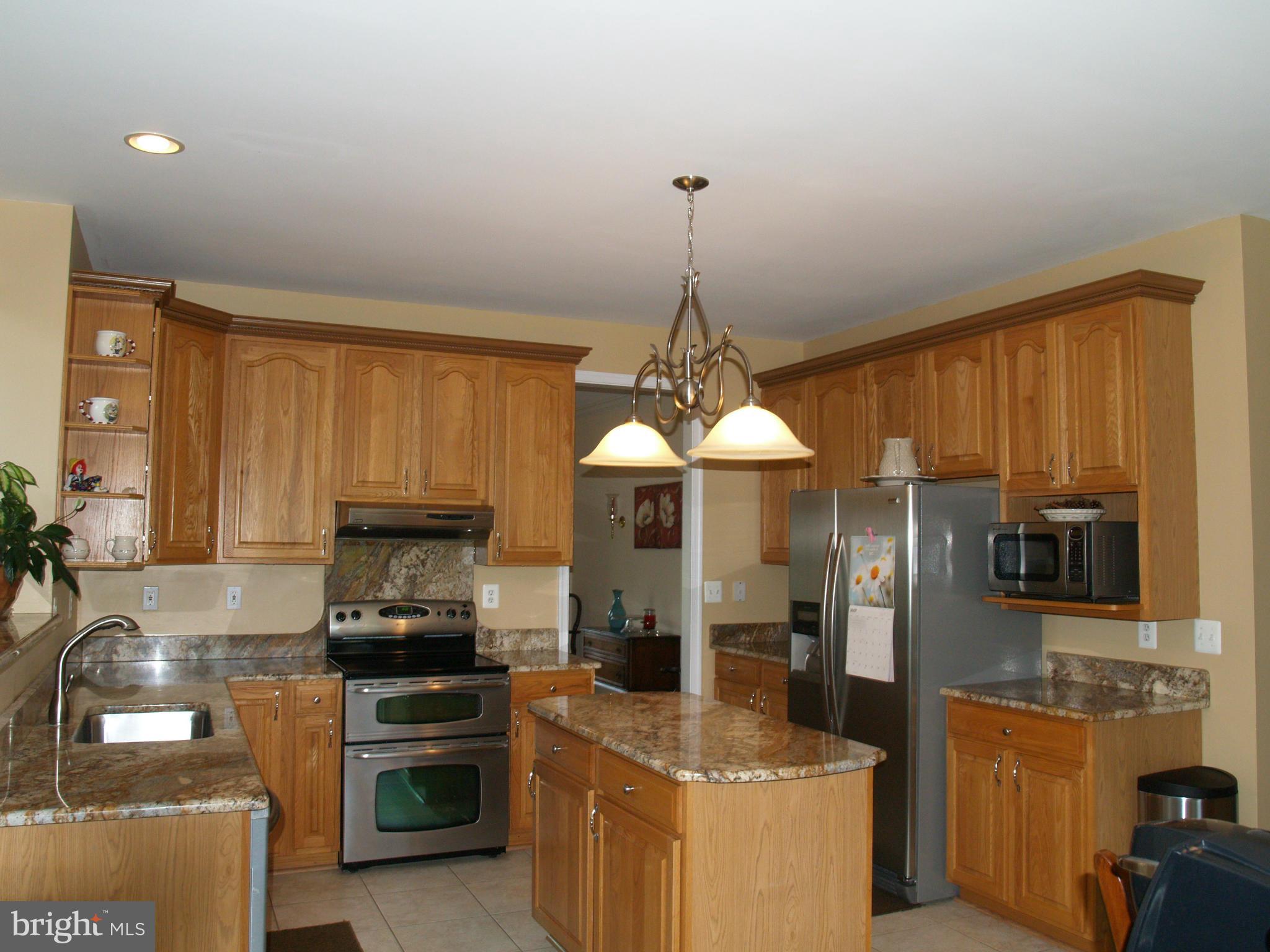 92 Friendship Road Friendship, MD 20758 - Photo 2 of 27 a kitchen with stainless steel appliances kitchen island granite countertop a stove and a refrigerator