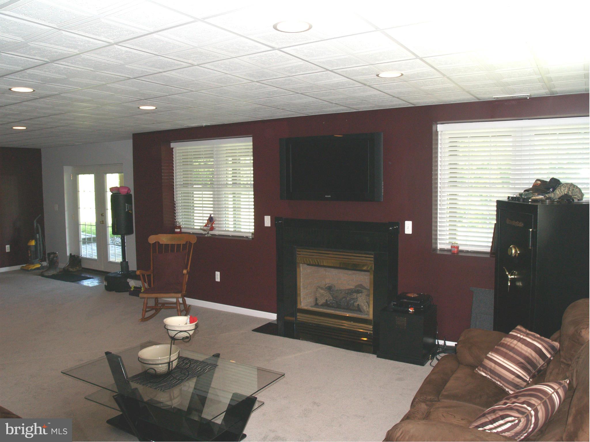 92 Friendship Road Friendship, MD 20758 - Photo 20 of 27 a living room with furniture a fireplace and a flat screen tv