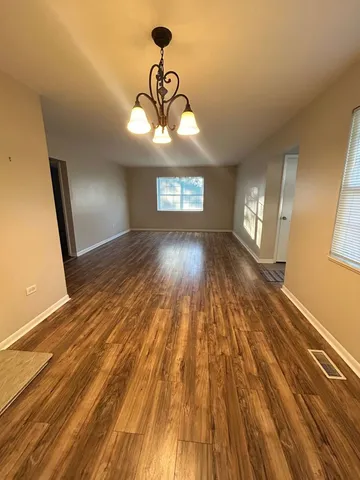 a view of a room with wooden floor and window