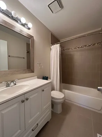 a bathroom with a double vanity sink toilet mirror and bathtub