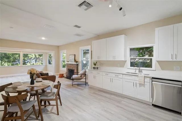 a kitchen with a dining table chairs and white cabinets