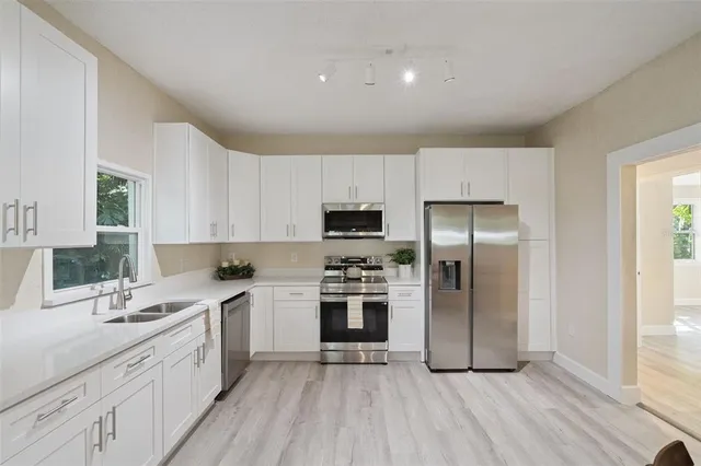 a kitchen with a sink stainless steel appliances and cabinets