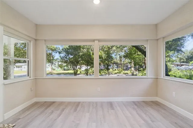 an empty room with wooden floor and a window
