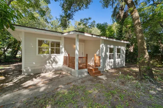 a view of a house with backyard and sitting area