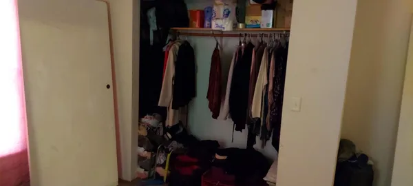 a view of walk in closet with clothes and shoes