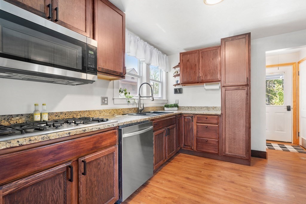 8 Lindbergh Road Framingham, MA 01702 - Photo 9 of 25 a kitchen with stainless steel appliances granite countertop wooden cabinets a stove top oven a sink and dishwasher