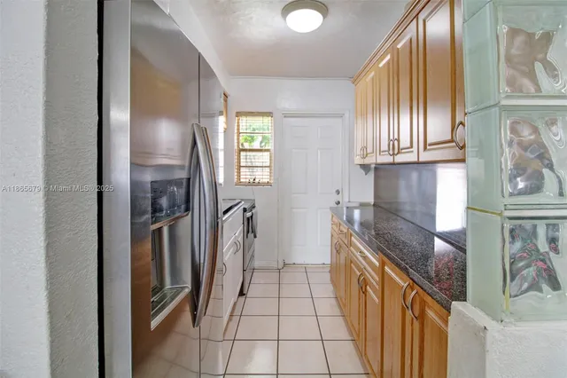a kitchen with stainless steel appliances granite countertop a refrigerator and a sink
