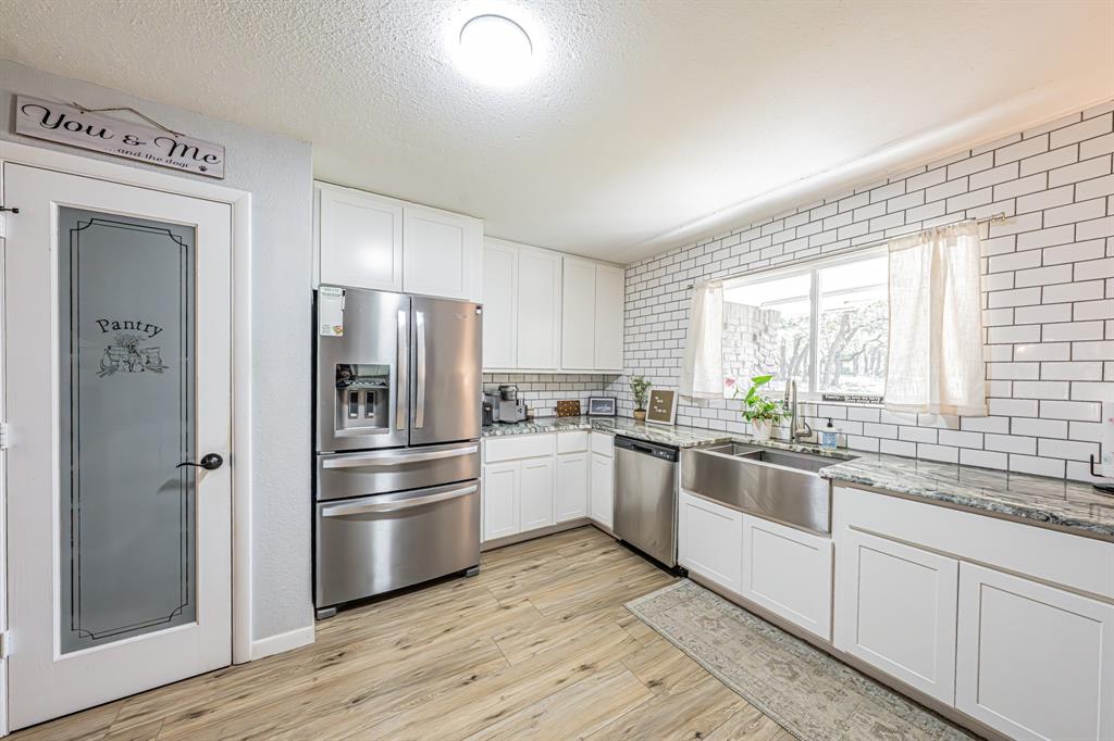 3745 Lucy Trimble Road Burleson, TX 76028 - Photo 14 of 40 a kitchen with a sink a refrigerator and wooden floor