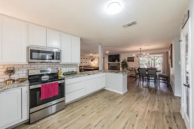 a kitchen with stainless steel appliances wooden floors and wooden cabinets