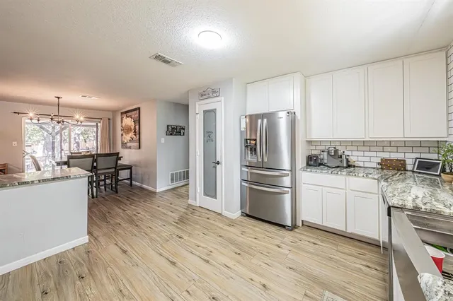 a kitchen with a refrigerator and wooden floor
