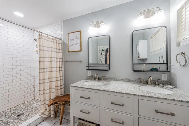 a bathroom with a double vanity sink and a mirror