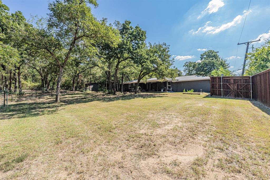 3745 Lucy Trimble Road Burleson, TX 76028 - Photo 29 of 40 a swimming pool that has lawn chairs and a dining table under an umbrella