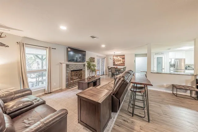 a living room with furniture stove and wooden floor