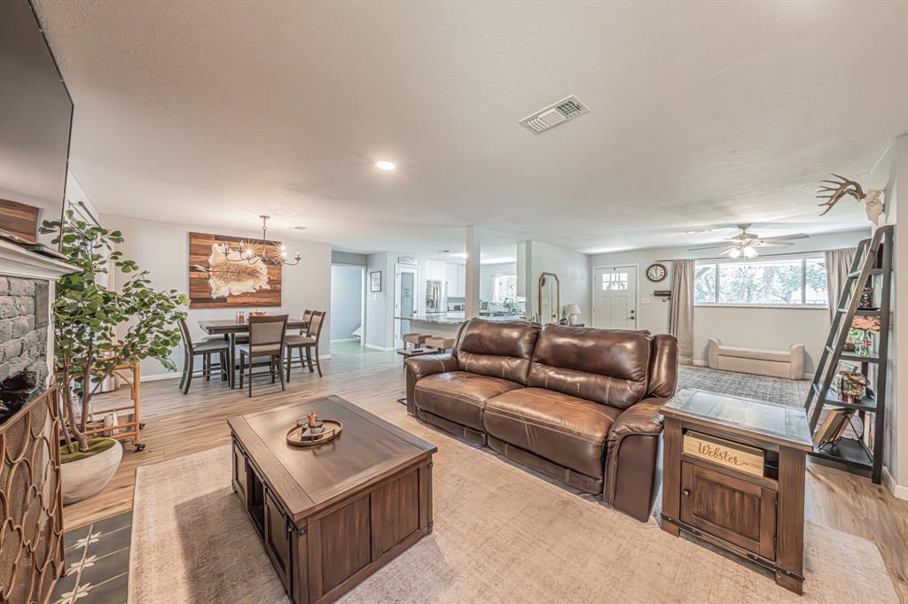 3745 Lucy Trimble Road Burleson, TX 76028 - Photo 6 of 40 a living room with furniture a lamp and a dining table with wooden floor