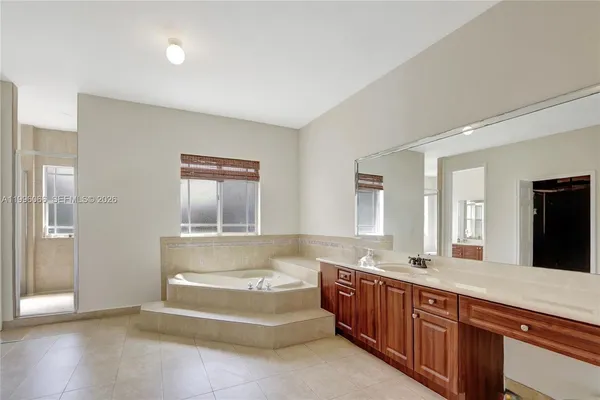 a spacious bathroom with a tub double sink and mirror