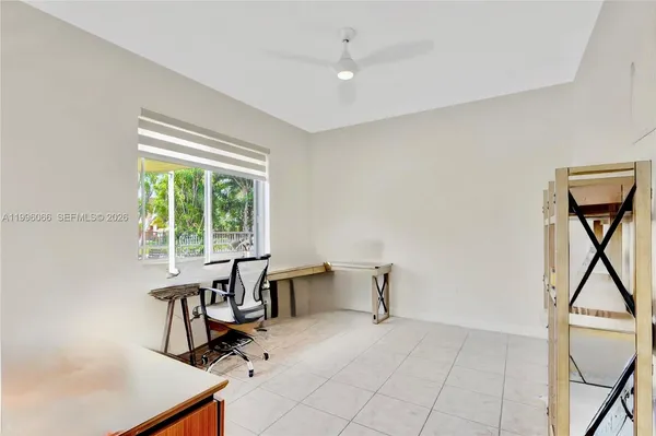a view of a workspace with furniture and a window
