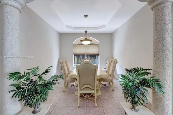 a dining room with furniture and potted plants