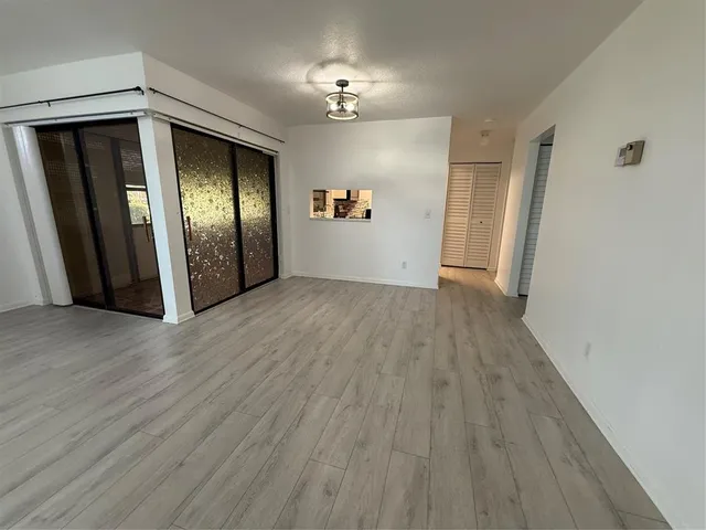 a view of a hallway with wooden floor and a chandelier