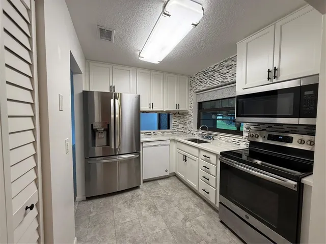 a kitchen with stainless steel appliances and white cabinets