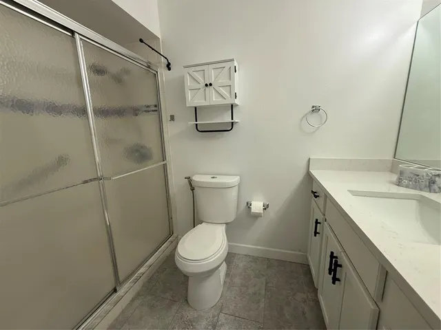an empty room with wooden floor chandelier fan and windows