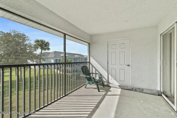 a view of a balcony with wooden floor and fence