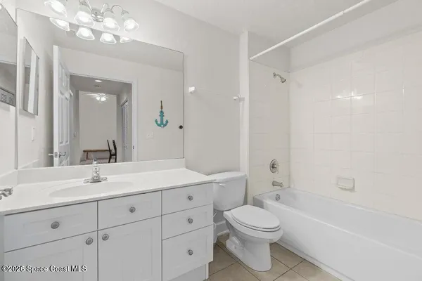 a bathroom with a toilet a sink a mirror a bathtub and vanity