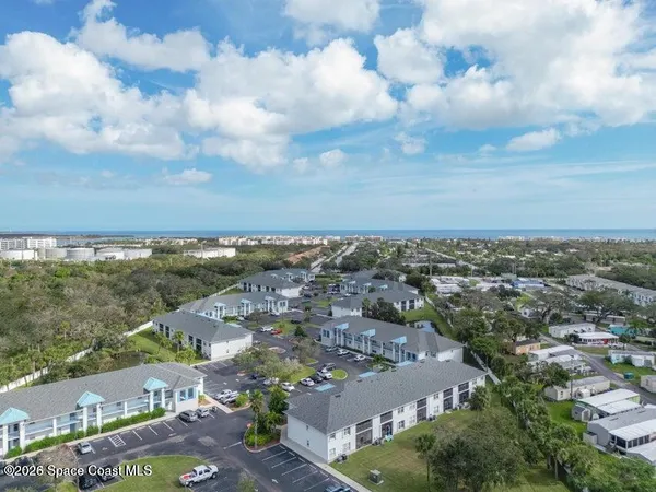 an aerial view of residential building and car parked on street