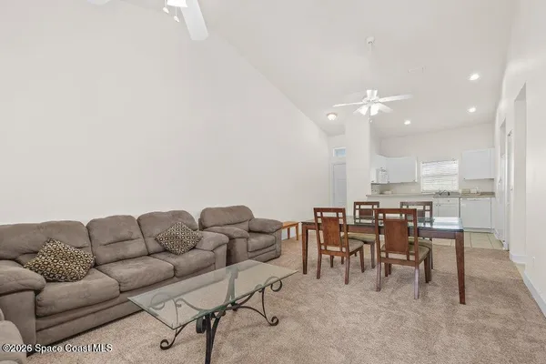 a living room with furniture kitchen view and a dining table