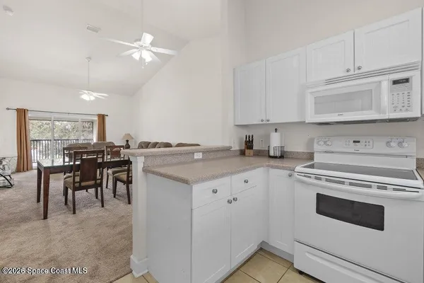 a kitchen with cabinets appliances and a dining table