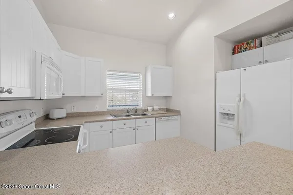 a kitchen with granite countertop a refrigerator and a sink