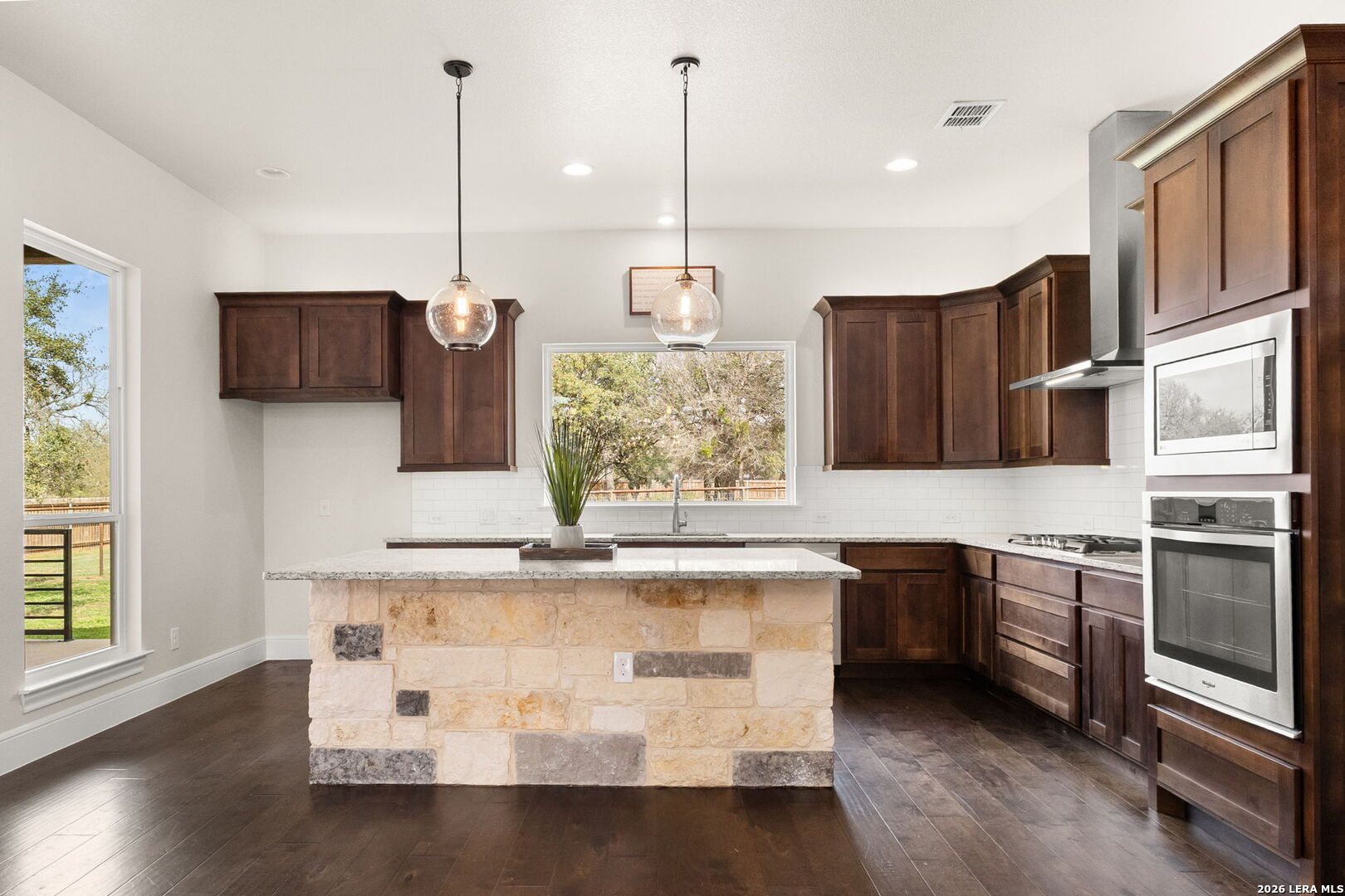 1217 Paladin Trail Spring Branch, TX 78070 - Photo 9 of 53 a kitchen with stainless steel appliances granite countertop a stove a sink and a wooden floors