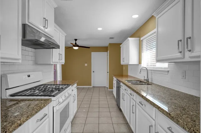 a kitchen with a sink stove top oven and cabinets