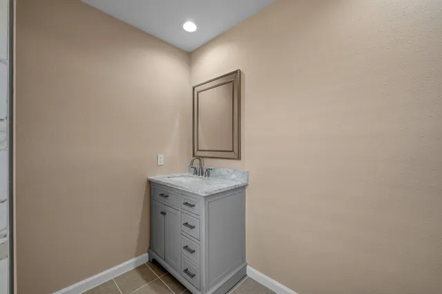 a bathroom with a granite countertop sink and a mirror