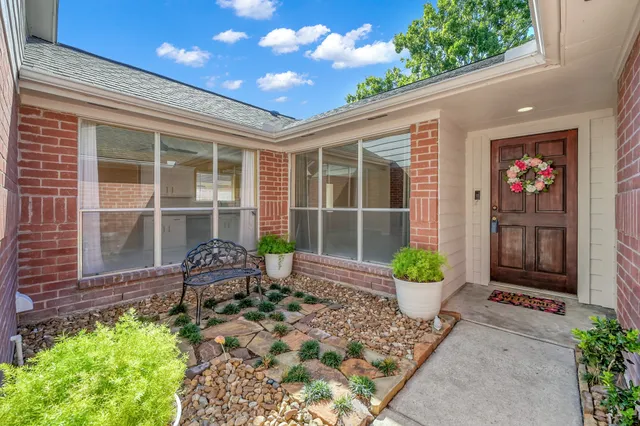 a front view of a house with a chairs and potted plant