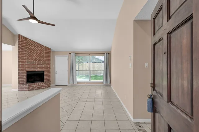 a view of an empty room with a fireplace and a window