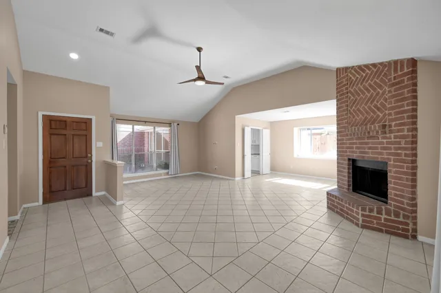 a view of empty room with fireplace and windows