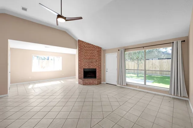 a view of an empty room with a fireplace and a window