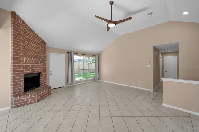 a view of an empty room with a fireplace and a window
