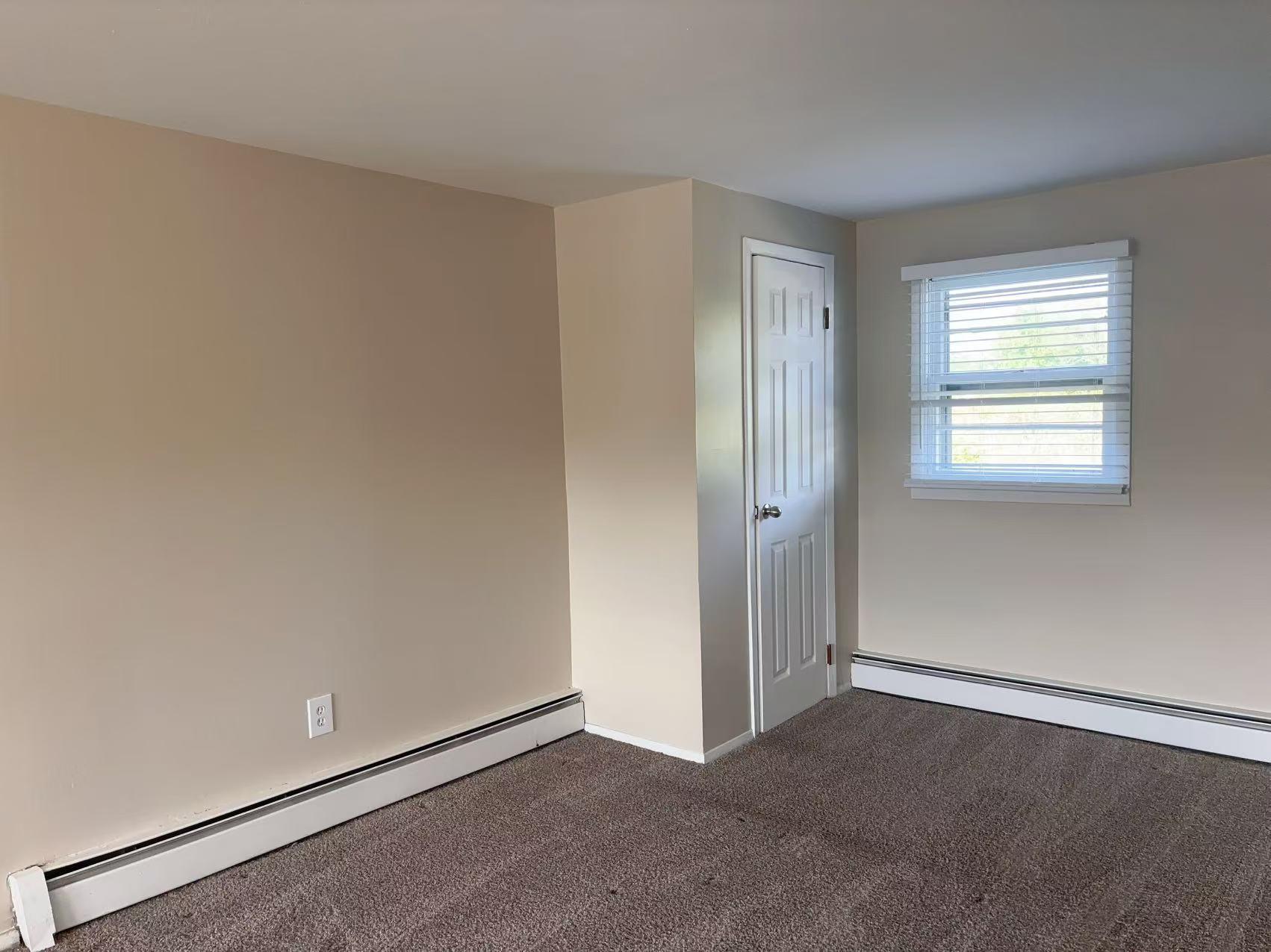 2333 Beech Street Wantagh, NY 11793 - Photo 14 of 21 Empty room featuring a baseboard heating unit, dark colored carpet, and baseboards