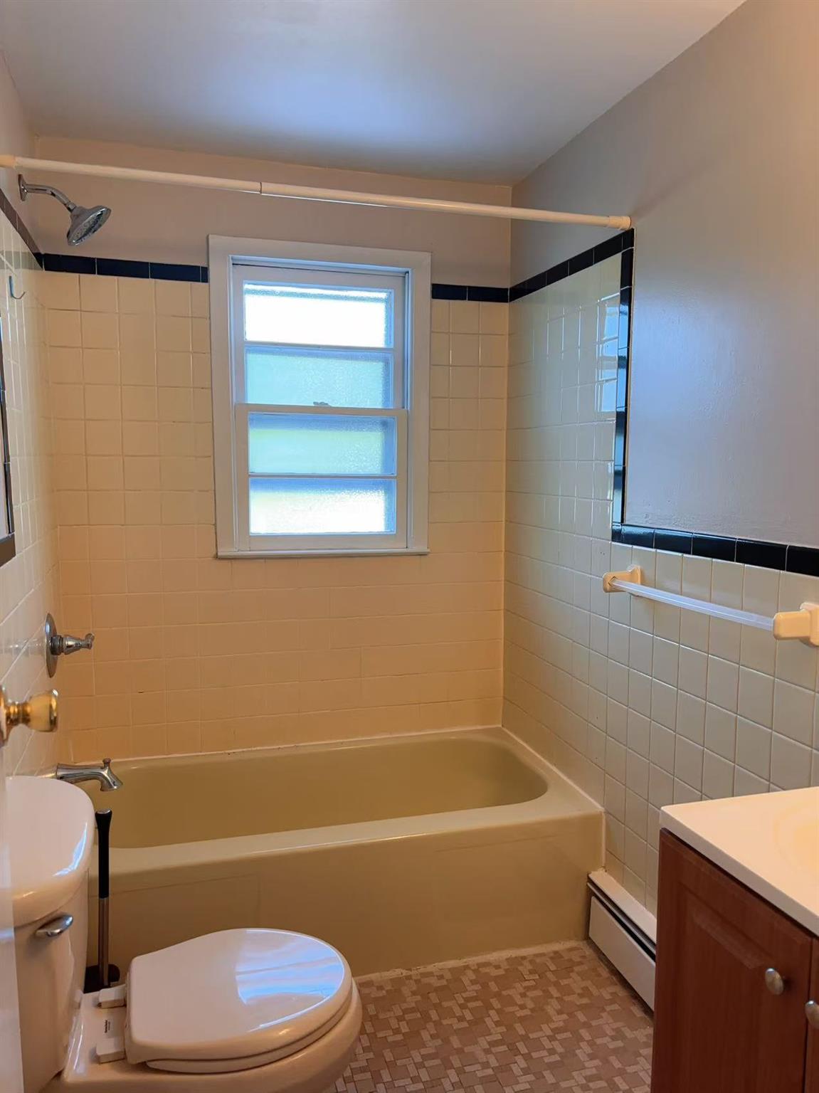 2333 Beech Street Wantagh, NY 11793 - Photo 15 of 21 Bathroom with baseboard heating, toilet, washtub / shower combination, and tile walls