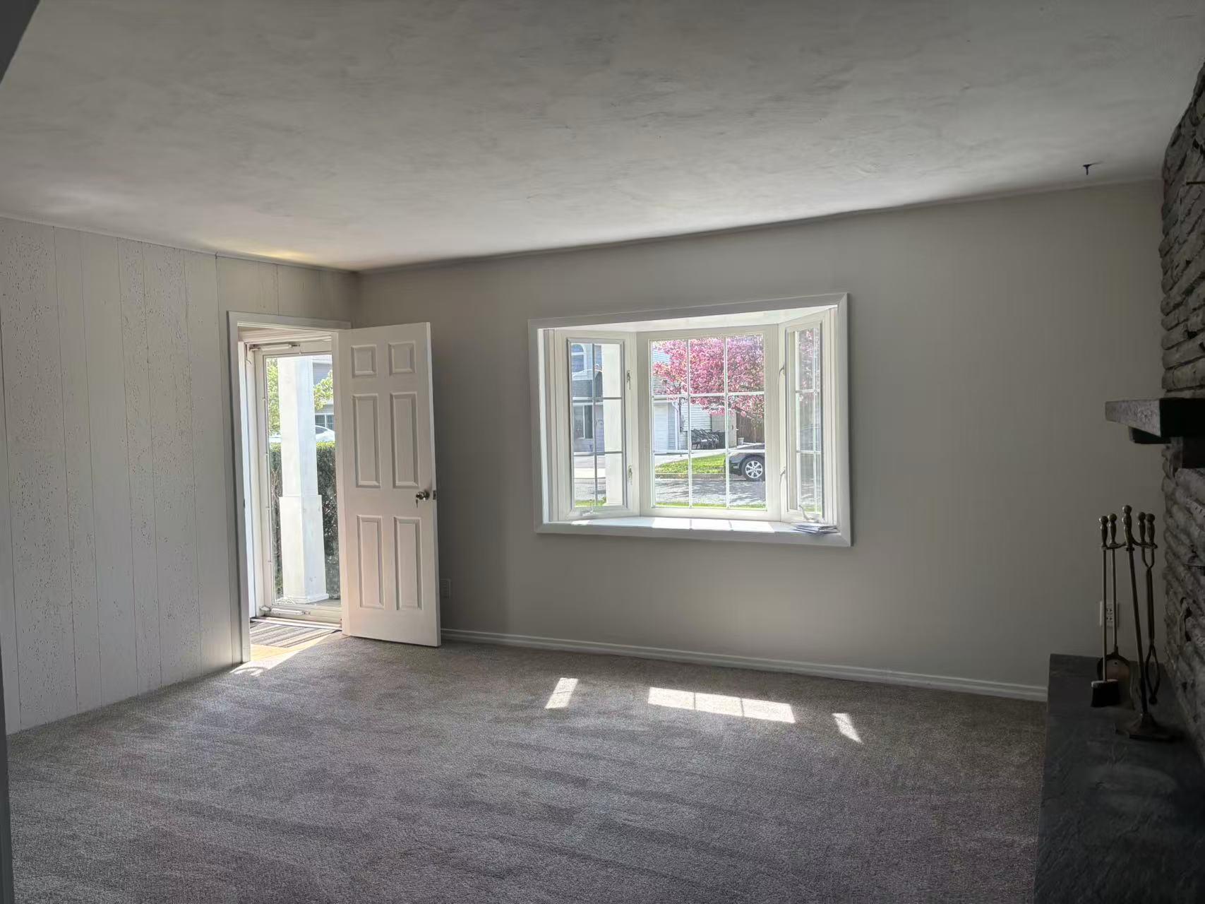 2333 Beech Street Wantagh, NY 11793 - Photo 2 of 21 Unfurnished living room featuring a stone fireplace, carpet floors, and wood walls
