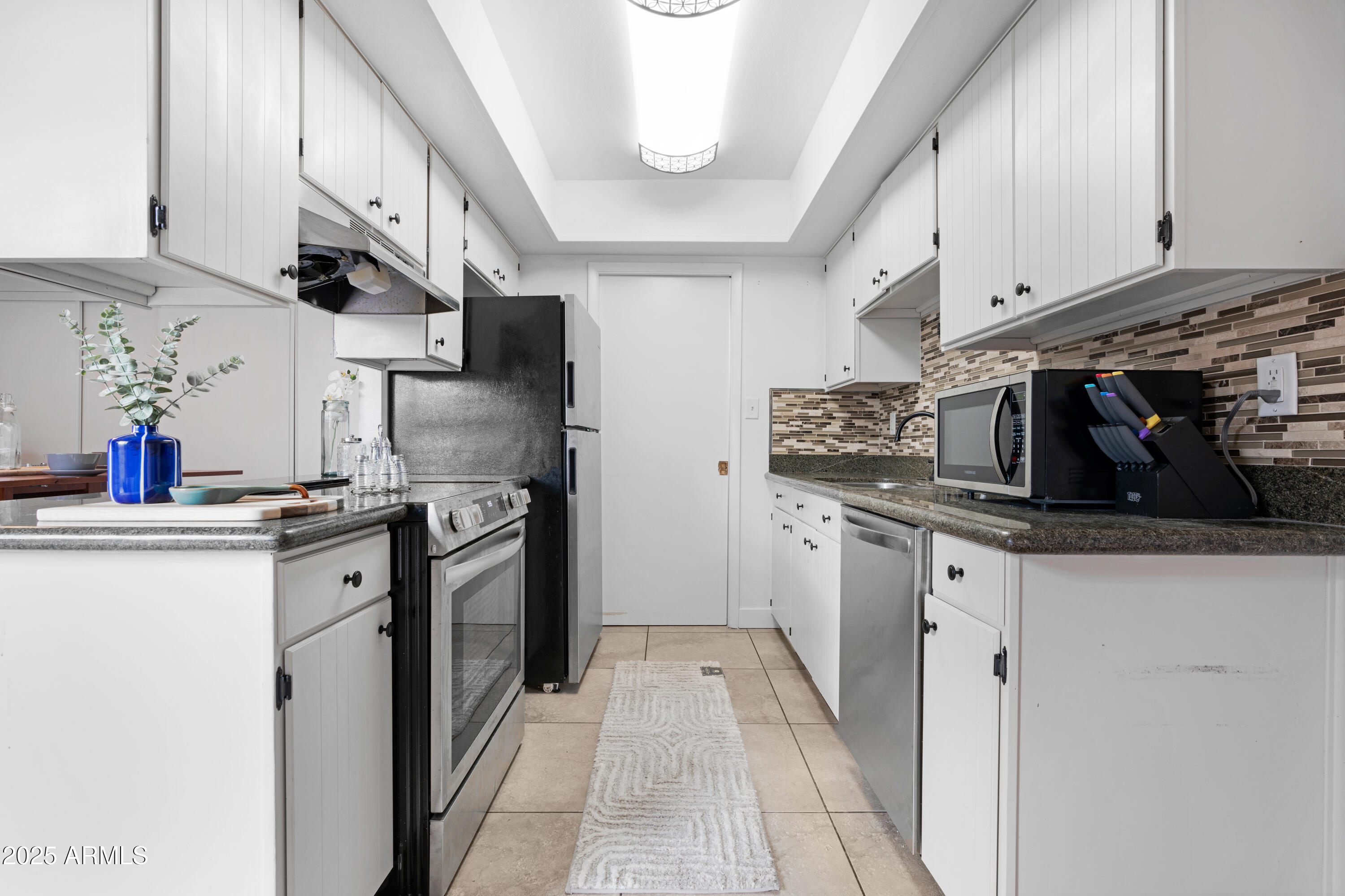 2042 West Elm Street Phoenix, AZ 85015 - Photo 14 of 35 a kitchen with stainless steel appliances granite countertop a sink a stove and cabinets